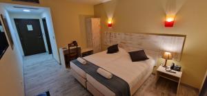 新伊達尼亞的住宿－Hotel Vila Raia，一间卧室配有一张大床和一张带台灯的桌子