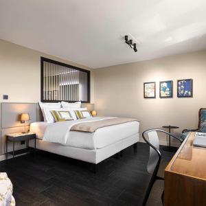 a bedroom with a large white bed and a desk at La maison py in Vergisson