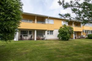 a yellow building with a lawn in front of it at Best possible location, 1 bedroom apartment in Närpiö