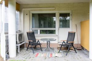 a patio with three chairs and a table and a window at Cosy 1 bedroom apartment with terrace and sauna, best location in Närpiö +14 photos
