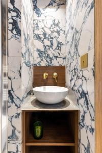 ein Badezimmer mit einem weißen Waschbecken auf der Theke in der Unterkunft CMG- Charming appartement 2P - Batignolles in Paris