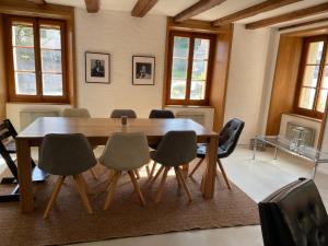 a dining room with a wooden table and chairs at Magnifique villa avec carnotzet proche de la gare in Romont