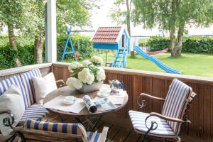 patio con mesa, sillas y parque infantil en Ferienhaus Großes Meer, en Bedekaspel