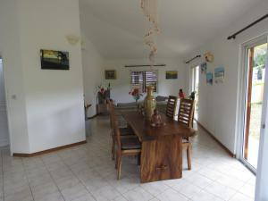 eine Küche und ein Esszimmer mit einem Holztisch und Stühlen in der Unterkunft VILLA CANELLE in Trou aux Biches