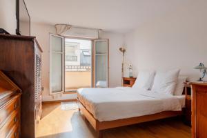- une chambre avec un lit et une grande fenêtre dans l'établissement Beaudelaire Center Residence, à Paris