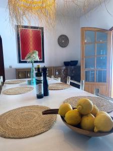 a table with a bowl of lemons on it at Authentic Villa with amazing pool in Santa Gertrudis de Fruitera