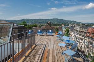 a deck with chairs and tables on a balcony at Alma Hotel in Zürich