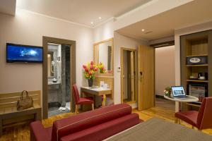a living room filled with furniture and a tv at Hotel Giolli Nazionale in Rome