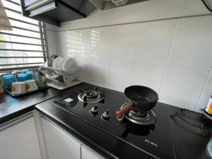 cocina con fogones negros en kuala selangor homestay skymirror firefly en Kuala Selangor