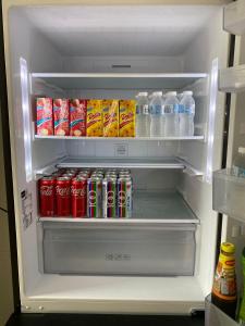 an open refrigerator with drinks and cans of soda at kuala selangor homestay skymirror firefly in Kuala Selangor