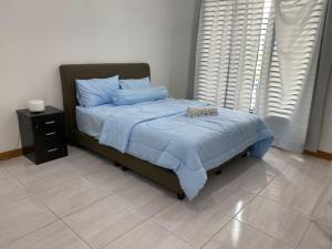 1 dormitorio con 1 cama con sábanas azules y mesita de noche en kuala selangor homestay skymirror firefly en Kuala Selangor
