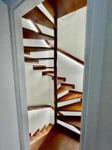 a winding staircase in a room with wood treads at Villetta le Rondini in Lignano Sabbiadoro
