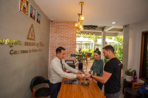 Eine Gruppe von Männern, die um einen Tisch stehen und Hände schütteln. in der Unterkunft Cambana La Rivière Hotel in Battambang