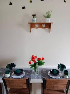 einen Tisch mit zwei Stühlen und eine Vase mit Blumen darauf in der Unterkunft AVIDA ATRIA T2-F ,5mins TO FESTIVE WALK AND 4 MINS TO ILOILO CONVENTION CENTER in Iloilo City