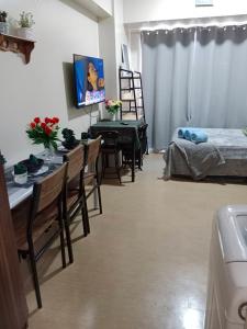 ein Wohnzimmer mit einem Bett, einem Tisch und Stühlen in der Unterkunft AVIDA ATRIA T2-F ,5mins TO FESTIVE WALK AND 4 MINS TO ILOILO CONVENTION CENTER in Iloilo City