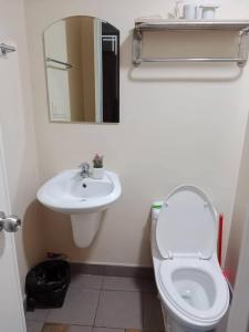 ein Badezimmer mit einem WC, einem Waschbecken und einem Spiegel in der Unterkunft AVIDA ATRIA T2-F ,5mins TO FESTIVE WALK AND 4 MINS TO ILOILO CONVENTION CENTER in Iloilo City