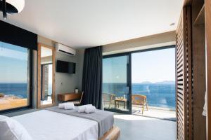 A bed or beds in a room at Seafront elegant villas, with infinity pools & devine views!