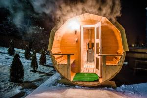 a round cabin with a door in the snow at Willa Azja SPA & Wellness in Zakopane