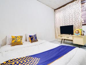 Un pat sau paturi într-o cameră la SPOT ON 91609 Pondok Mill's Syariah