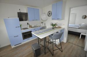cocina con armarios azules, mesa y sillas en Landhaus Sandra, en Lütow