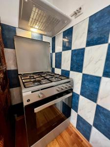 cocina con fogones y azulejos azules y blancos en CASA CU LAVANDĂ, en Vatra Dornei