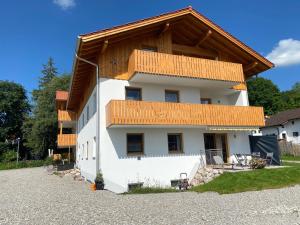 a large white house with a wooden roof at Ferienwohnung Hipp - Bockstallsee in Halblech