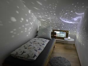 een slaapkamer met een bed en een muur met sterren bij Ferienwohnung Hipp - Bockstallsee in Halblech