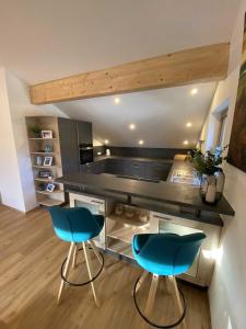 a kitchen with two blue chairs and a counter at Ferienwohnung Hipp - Bockstallsee in Halblech