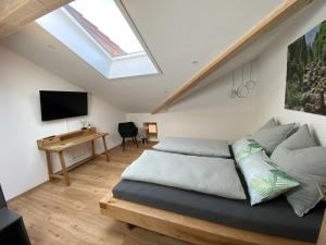 een slaapkamer met een bed, een bureau en een dakraam bij Ferienwohnung Hipp - Bockstallsee in Halblech