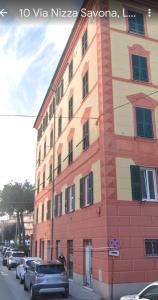 a tall building with cars parked in front of it at La casa di Grace in Savona