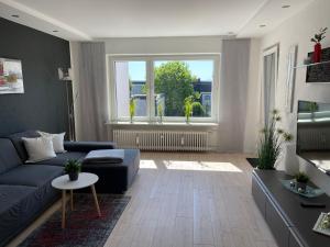 uma sala de estar com um sofá azul e uma grande janela em Live to Lion em Braunschweig