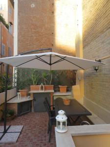 een patio met een tafel en een parasol bij Terrace in Monti44a in Rome
