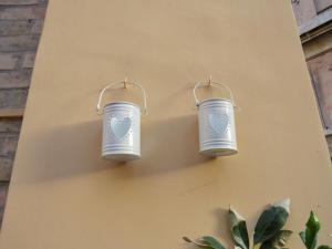 two blue buckets hanging on the side of a wall at Terrace in Monti44a in Rome +2 photos