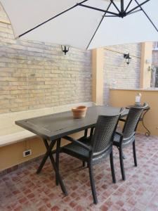 een tafel met twee stoelen en een parasol bij Terrace in Monti44a in Rome