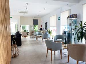 a waiting room with chairs and tables in a building at Hotel Senderos in Agua Amarga