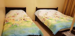 two beds sitting next to each other in a bedroom at Crown Imperial Court Apartment (Madam Ng)1 in Cameron Highlands