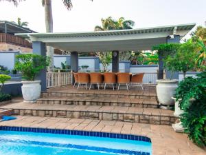a patio with chairs next to a swimming pool at Royal Guesthouse in Mtunzini