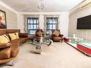 a living room with leather furniture and a flat screen tv at Royal Guesthouse in Mtunzini