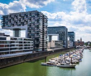 a group of boats docked in a river with buildings at Fantasie Boot EINHORN in Cologne