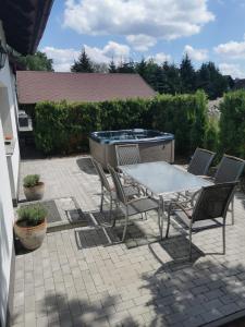 a patio with a table and chairs and a grill at Domek Karinka in Mysłakowice