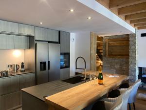 a kitchen with a table with a bottle of wine at Chalet Neuf du Pape in Les Deux Alpes