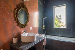 a bathroom with a sink and a tub and a mirror at ama Stays and Trails Casa Kenzo, Kashid in Mumbai