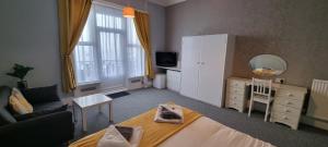 uma pequena sala de estar com uma cama e uma cómoda em Royal Pier em Sandown