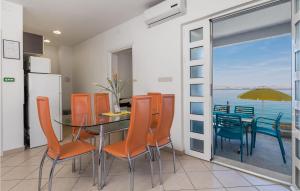 a dining room with a table and chairs and a view of the ocean at Awesome Apartment In Lukovo Sugarje With 2 Bedrooms And Wifi in Pavičići