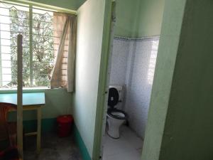 a small bathroom with a toilet and a window at Seva Kendra Hijli Kharagpur in Kharagpur