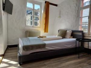 a bedroom with a bed in a room with windows at ReSt Inn Monschau in Monschau