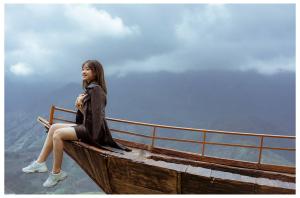 a young woman sitting on the edge of a boat at D Home Sapa 2 in Sa Pa