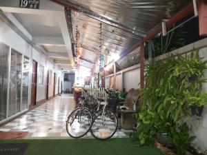 uma fila de bicicletas estacionadas num corredor com plantas em HILLDA HOUSE em Chiang Mai