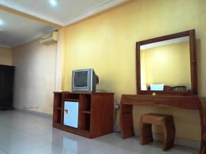 ein Wohnzimmer mit einem TV und einem Spiegel in der Unterkunft Panorama Hotel in Ubud