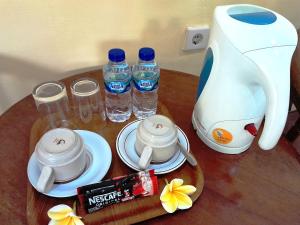 a table with a tea kettle and two bottles of water at Panorama Hotel in Ubud